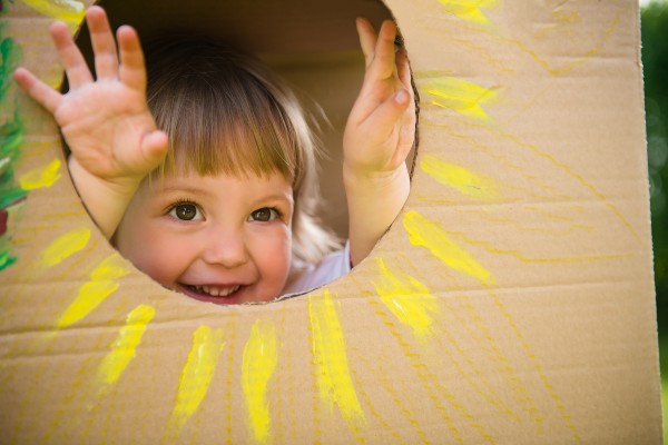 Little girl looking through hole
